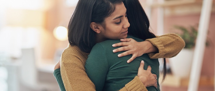 Two young women hugging each other after asking if they're okay.