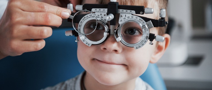 An eye test being conducted on a child by an optometrist.