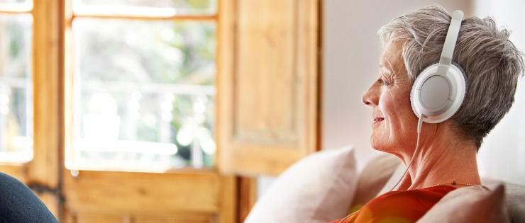 Mature aged woman listening to meditation and relaxing before bed to get a good night's sleep