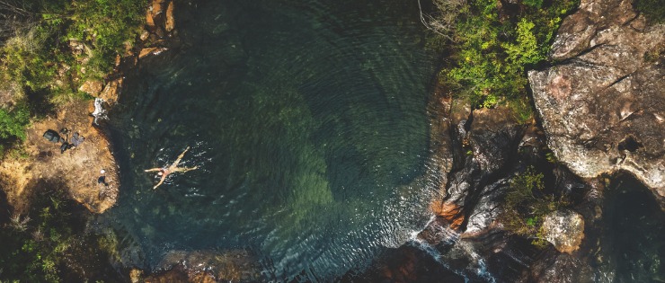 Drone view of woman swimming a natural pool in Sydney’s Royal National Park