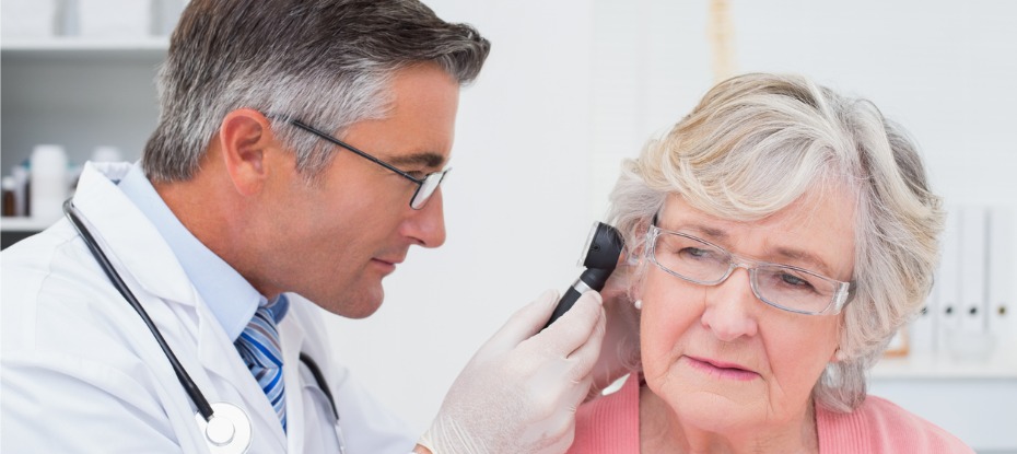 male GP examining older female’s ear