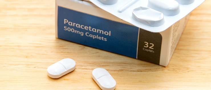 A packet of paracetamol painkiller medicine on a wooden table. 