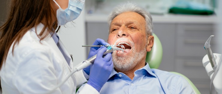  Mature aged man suffering from gum disease having a check up with dentist