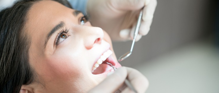 Female in dentist chair having a regular scale and clean on her teeth to avoid gingivitis 