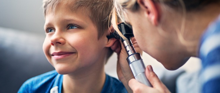 A young boy having his hearing checked by a specialist to see if he needs speech therapy.