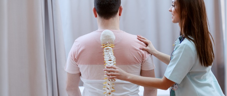 Female chiropractor performing spinal adjustment on male patient 