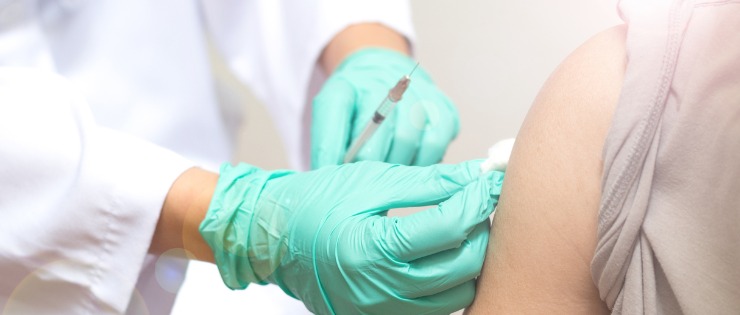 Nurse giving a vaccine to a woman to reduce the chance of developing cervical cancer 