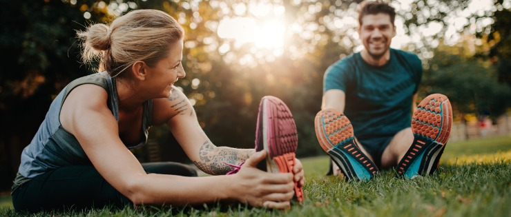 Young couple stretching in the park before going for a run to release feel-good-hormones