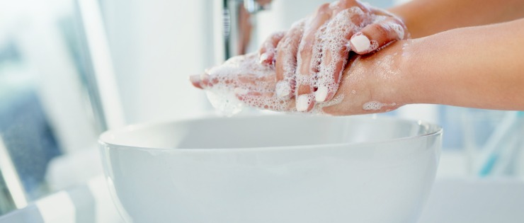 Pair of hands with soap being cleansed to prevent the flu. 