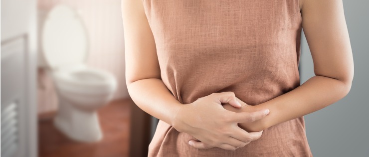 Young female holding her stomach suffering from irritable bowel syndrome (IBS)