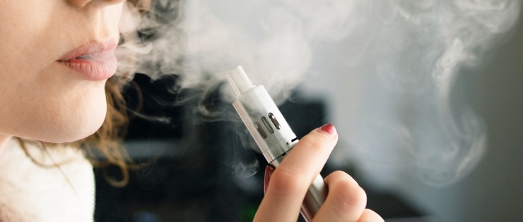 A woman using a vape with nicotine e-liquids prescribed to her by the doctor to help her quit.