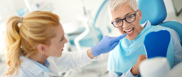 Dentist examining x-ray results with mature aged female patient 