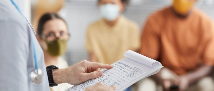 A surgeon holds an elective surgery waitlist in a hospital waiting room.