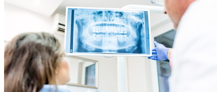 Male dentist explaining x-ray to patient